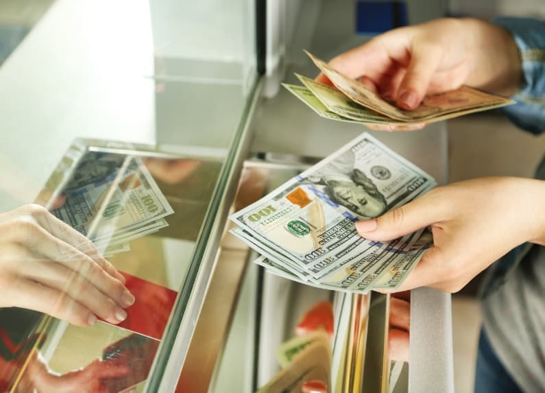 Person counting money at bank counter